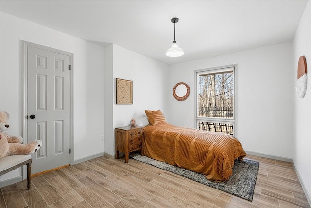 bedroom with light wood finished floors and baseboards