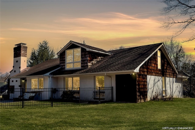 view of front facade with a front lawn, fence, and a garage