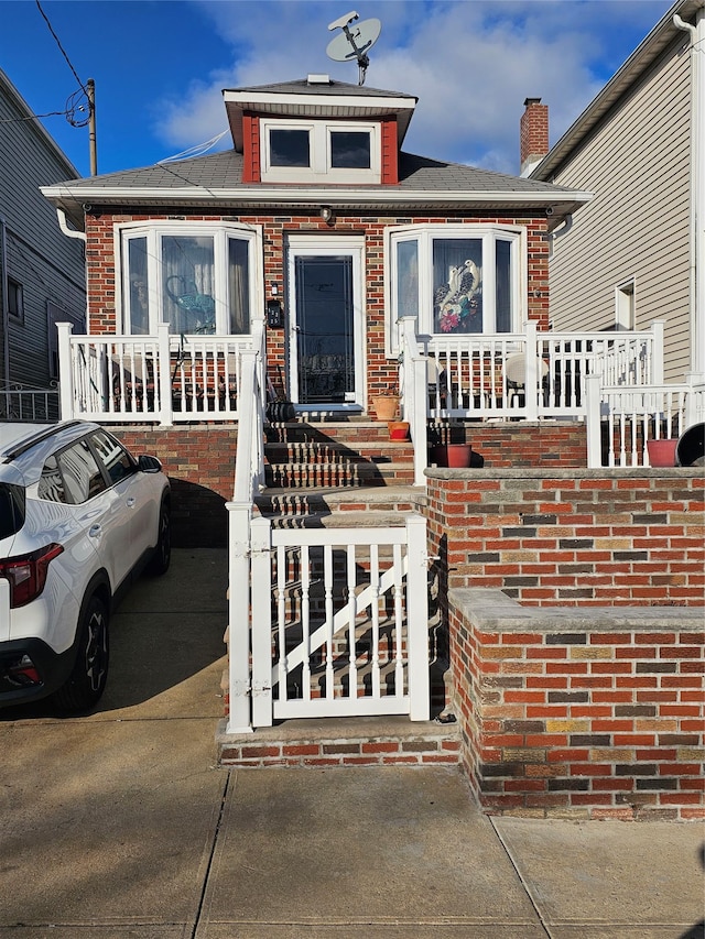 bungalow featuring brick siding