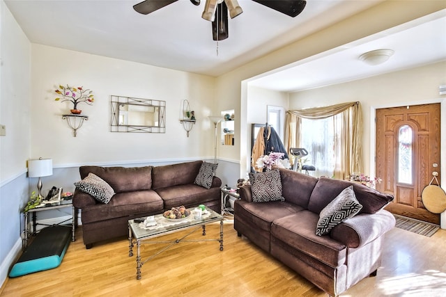 living area featuring light wood-style flooring and a ceiling fan