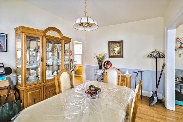 dining area with light wood finished floors and baseboards