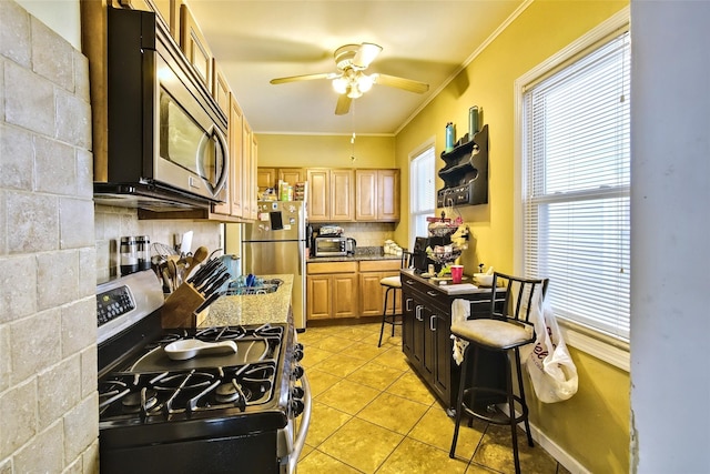 kitchen with light tile patterned flooring, light stone countertops, appliances with stainless steel finishes, decorative backsplash, and crown molding