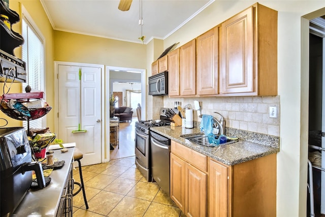 kitchen featuring appliances with stainless steel finishes, tasteful backsplash, a sink, and ornamental molding