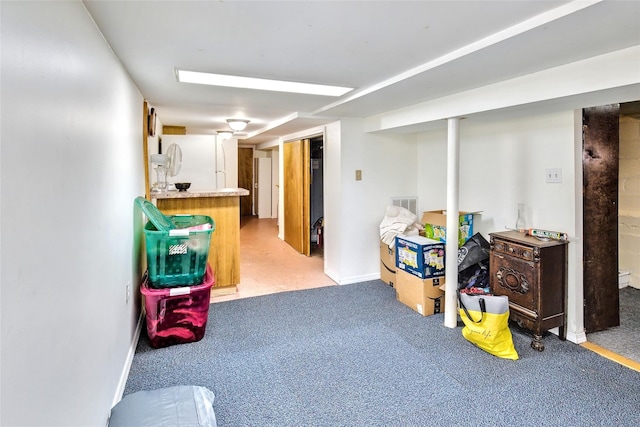 finished below grade area featuring light carpet, visible vents, and baseboards