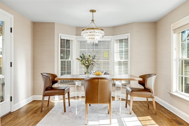 dining room with a chandelier, wood finished floors, and baseboards