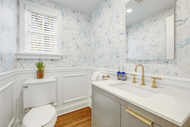 bathroom with wainscoting and wallpapered walls