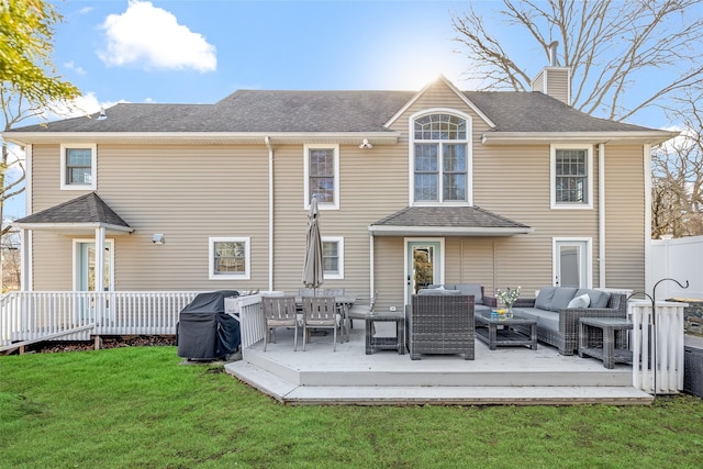 rear view of house featuring roof with shingles, a yard, a chimney, an outdoor hangout area, and a wooden deck