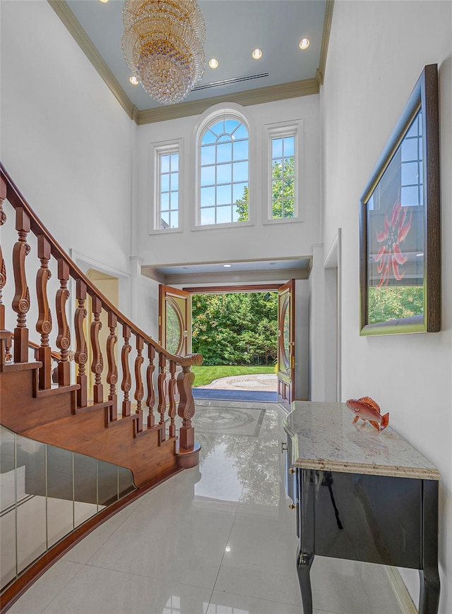 tiled foyer entrance featuring a towering ceiling, stairway, ornamental molding, a chandelier, and recessed lighting