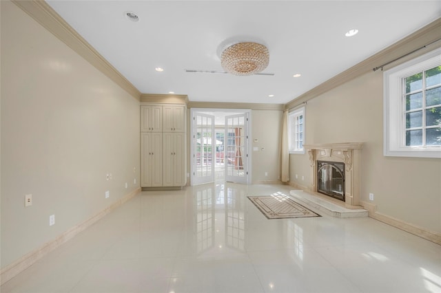 unfurnished living room featuring baseboards, ornamental molding, a premium fireplace, and a healthy amount of sunlight