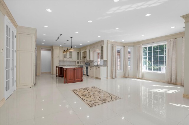 kitchen featuring light tile patterned floors, a sink, glass insert cabinets, and a center island