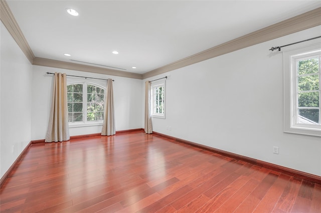 spare room with crown molding, baseboards, wood finished floors, and recessed lighting