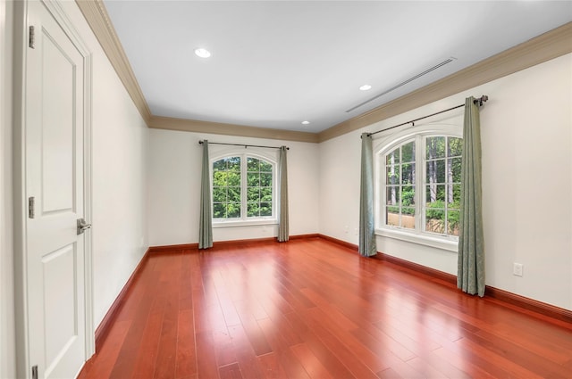 empty room featuring baseboards, dark wood finished floors, and crown molding