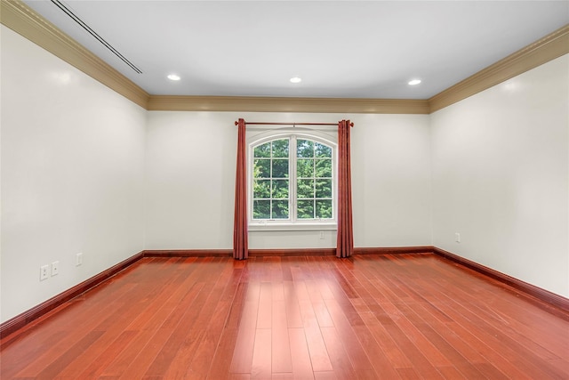 spare room with baseboards, recessed lighting, wood finished floors, and crown molding