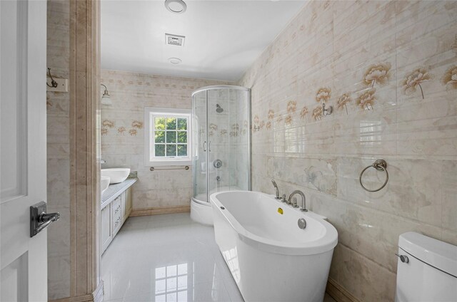 bathroom with toilet, tile walls, a soaking tub, tile patterned floors, and a stall shower