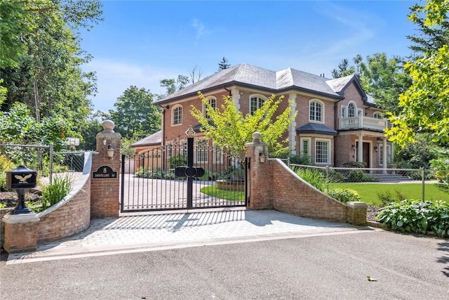 view of front of home featuring a fenced front yard, a gate, and brick siding