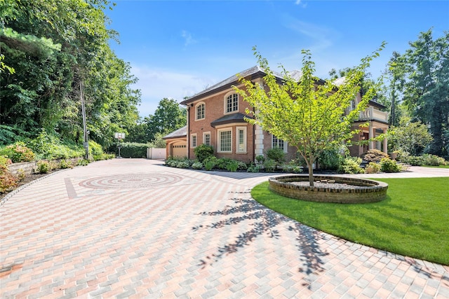 view of front of property featuring a front lawn, decorative driveway, and brick siding