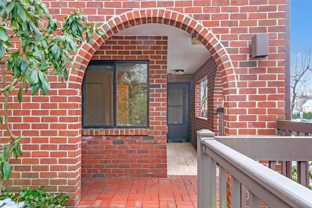 view of exterior entry featuring brick siding