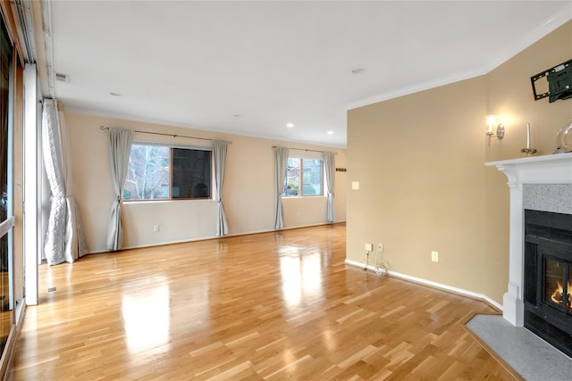 unfurnished living room featuring ornamental molding, wood finished floors, a fireplace with flush hearth, and baseboards