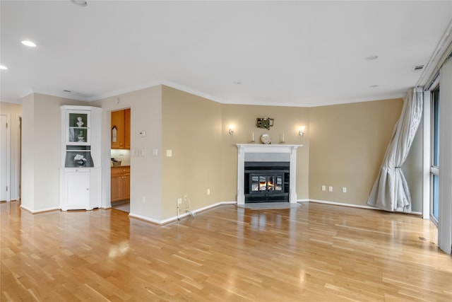 unfurnished living room featuring crown molding, a multi sided fireplace, light wood-style flooring, and baseboards