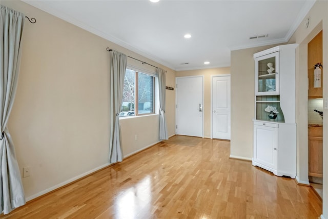 interior space with visible vents, baseboards, ornamental molding, light wood-type flooring, and recessed lighting