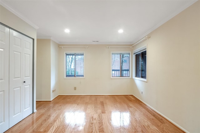 unfurnished bedroom featuring recessed lighting, a closet, light wood-style floors, ornamental molding, and baseboards