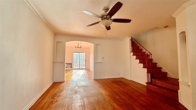 interior space with arched walkways, baseboards, wood finished floors, and crown molding