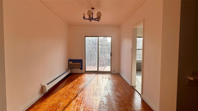 unfurnished room featuring a baseboard radiator, radiator heating unit, wood finished floors, a wall mounted air conditioner, and baseboards