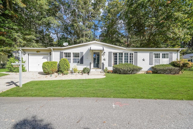 view of front of home featuring a front lawn, concrete driveway, and an attached garage