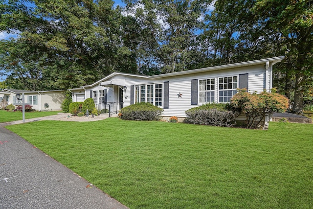 view of front of home with driveway and a front lawn