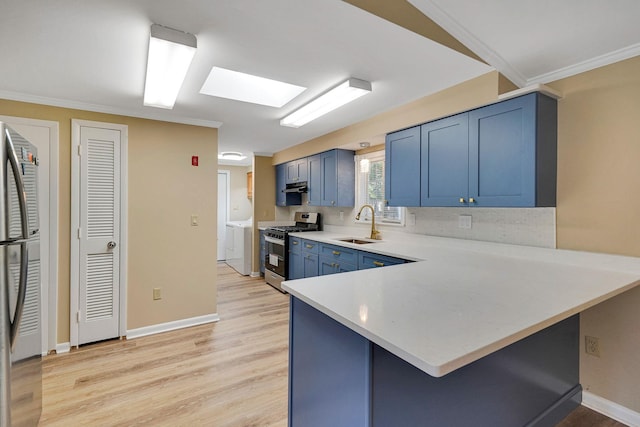 kitchen with light countertops, stainless steel gas stove, a sink, a peninsula, and a kitchen breakfast bar