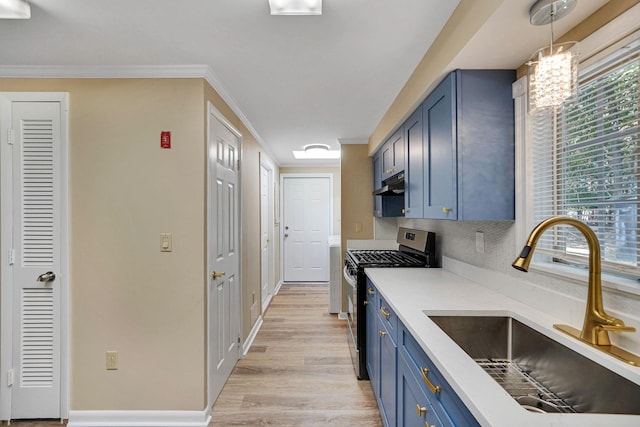 kitchen featuring light countertops, stainless steel gas stove, a sink, and blue cabinetry