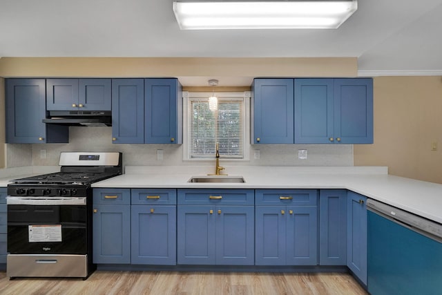 kitchen featuring under cabinet range hood, stainless steel appliances, a sink, light countertops, and blue cabinetry