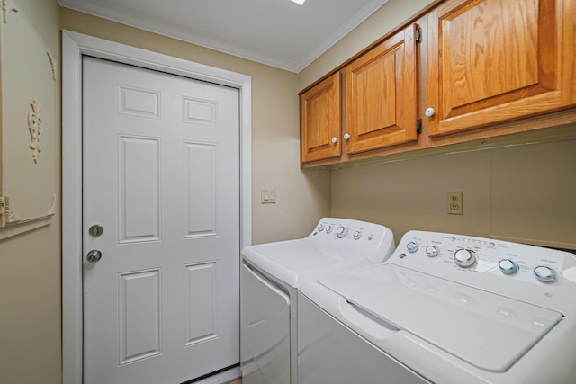 washroom with washing machine and dryer, cabinet space, and crown molding