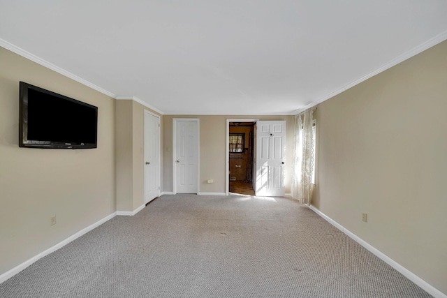 carpeted spare room with crown molding and baseboards