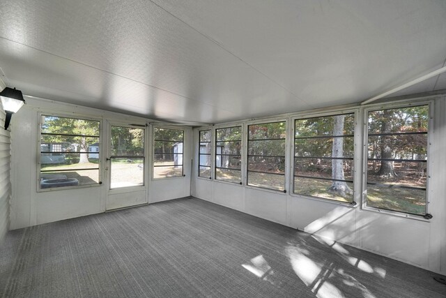 unfurnished sunroom featuring vaulted ceiling