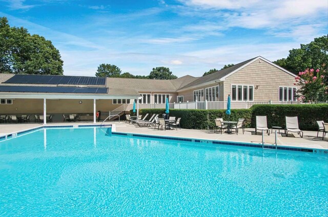 community pool featuring fence and a patio