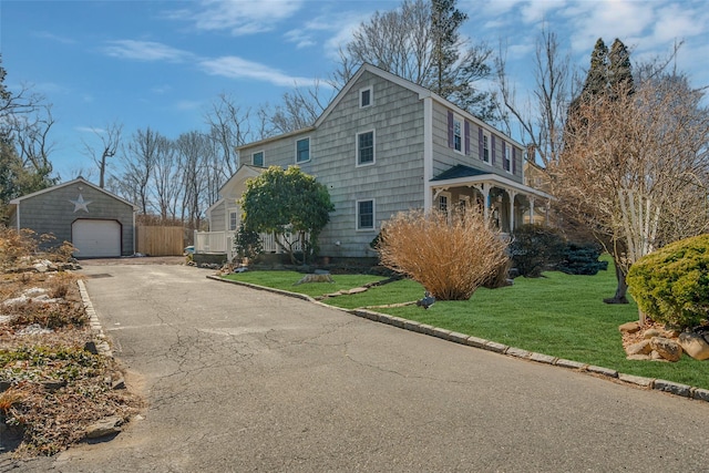 view of home's exterior featuring an outbuilding, a yard, aphalt driveway, and a garage