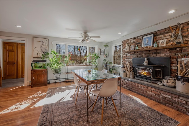 dining area with a baseboard heating unit, light wood-style flooring, and recessed lighting