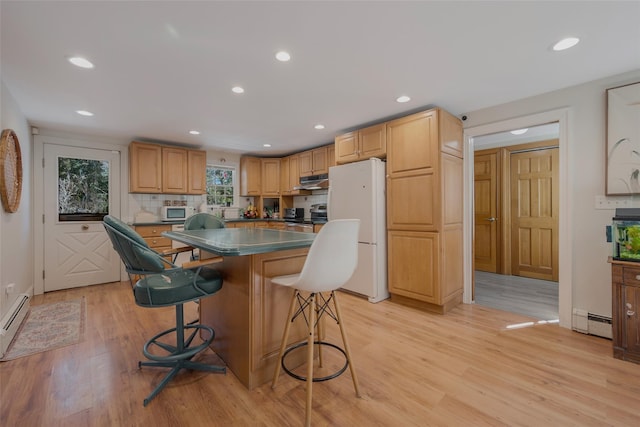 kitchen with a baseboard radiator, white appliances, a kitchen island, dark countertops, and a kitchen bar