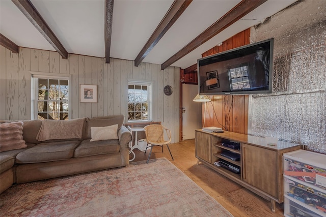 living area with beam ceiling and light wood-style floors