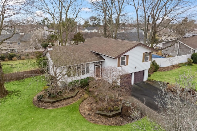 view of front of house with a garage, a front yard, driveway, and fence