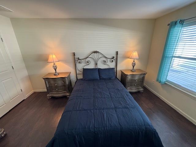 bedroom featuring dark wood-style floors and baseboards