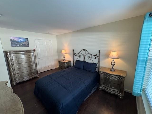 bedroom with baseboards and dark wood-style flooring