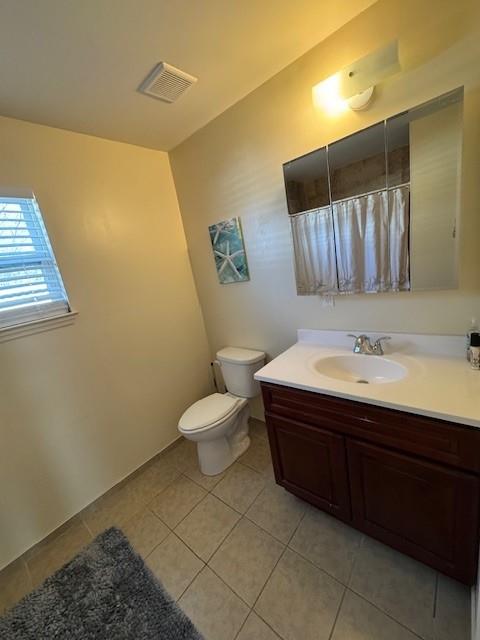 bathroom with toilet, tile patterned floors, vanity, visible vents, and a shower with curtain