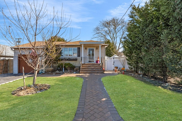 single story home with brick siding, a front yard, a gate, fence, and driveway