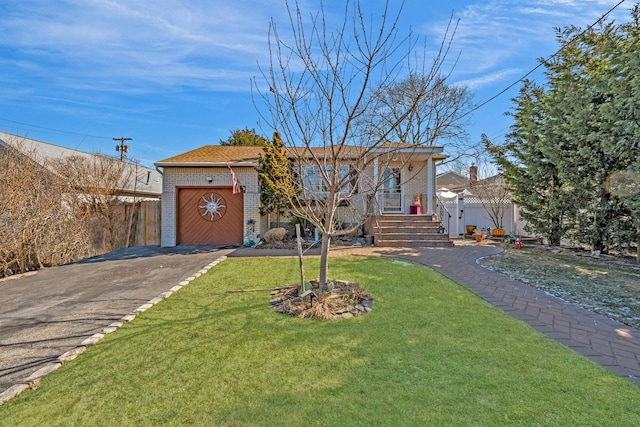 ranch-style home featuring driveway, brick siding, and a front lawn