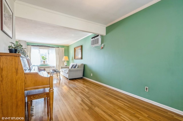 unfurnished room featuring a wall unit AC, crown molding, baseboards, and wood finished floors