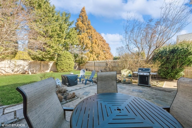 view of patio featuring outdoor dining area, a fenced backyard, and a grill