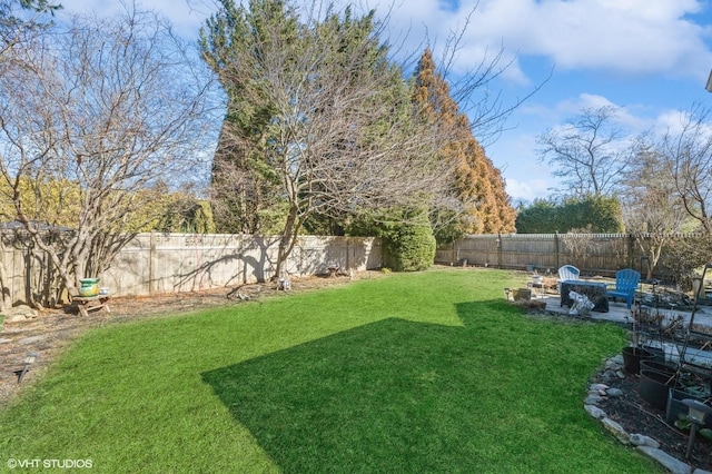 view of yard with an outdoor fire pit, a fenced backyard, and a patio