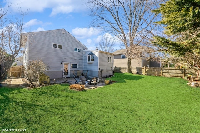 rear view of property with a fenced backyard, a lawn, and a patio